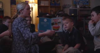 Teacher reading book to children.