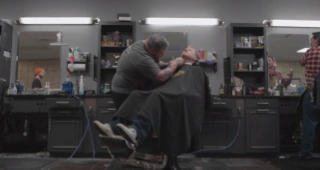 Barber giving haircut to client.