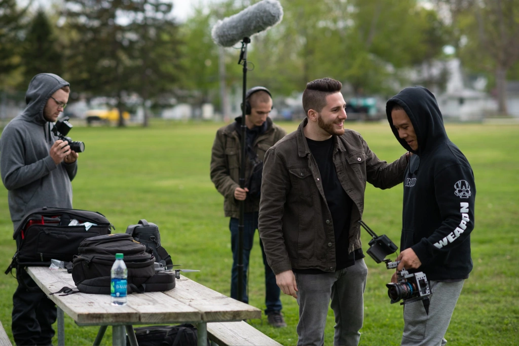 Group of Filmmakers Collaborating Outdoors with Professional Equipment